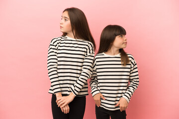 Little sisters girls isolated on pink background nervous and scared