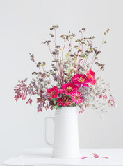 flowers in white jug on white background