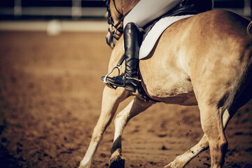 Equestrian sport. The leg of the rider in the stirrup, riding on a horse.