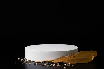 White podium on the black background with golden feather and small crystals. Podium for product,...
