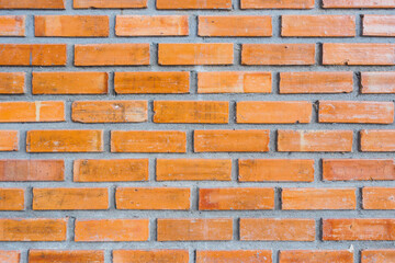 The textures of the orange brick blocks and grey concrete are arranged beautifully and neatly to be the wall