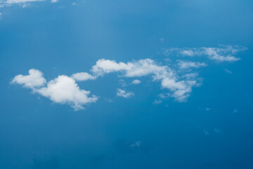 Aerial view scene of the sea or ocean which hiding under white fluffy clouds.