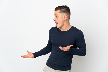 Young caucasian man isolated on white background with surprise expression while looking side