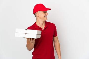 Pizza delivery man with work uniform picking up pizza boxes isolated on white background looking...
