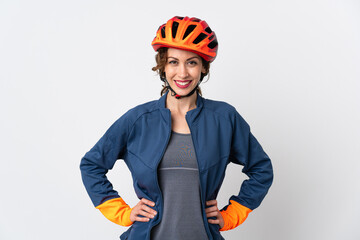 Young cyclist woman isolated on white background posing with arms at hip and smiling