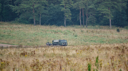 with faces obfuscated - british army artillery towed behind an all terrain vehicle on a military exercise Wiltshire UK © Martin
