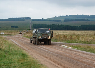 British army Steyr-Daimler-Puch BAE Systems Pinzgauer high-mobility 6x6 all-terrain vehicle tows a 105mm L118 Light Gun on military exercise Wilts UK © Martin