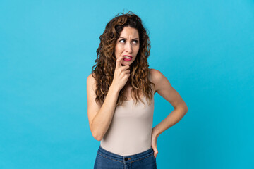 Young caucasian woman isolated on blue background nervous and scared