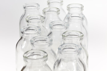 Kleine durchsichtige Glasflaschen vor weißem Hintergrund.
