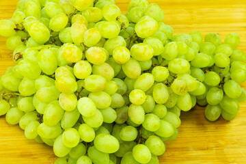 bunch of green grapes on wood