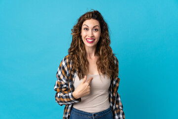 Young caucasian woman isolated on blue background with surprise facial expression