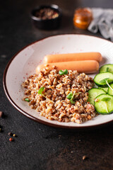 buckwheat porridge and sausages fresh salad cucumber ready to eat meal snack on the table copy space food background rustic 