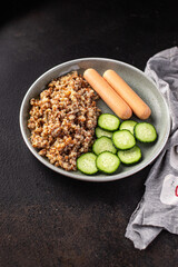 buckwheat porridge and sausages fresh salad cucumber ready to eat meal snack on the table copy space food background rustic 