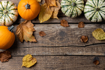 Festive autumn decor from pumpkins and autumn leaves on rustic wooden background. Concept of Thanksgiving day or Halloween. Flat lay autumn composition with copy space