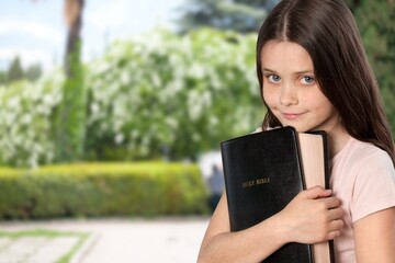 Fototapeta premium smart and nerd kid girl holding Bible for study in church.