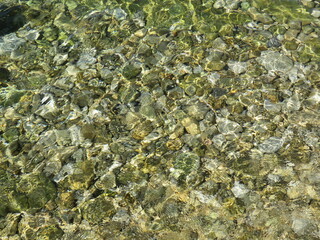 Kiesel, Steine am Strand unter Wasser