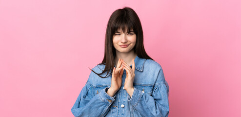 Young Ukrainian woman isolated on pink background scheming something