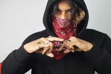 Foto op Aluminium Young thug Indian male with a bandana covering his face doing gang signs © Santosh Kharat/Wirestock