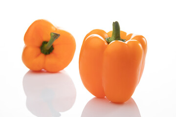 Two orange bell peppers isolated on white background, one of them is out of focus, bokeh