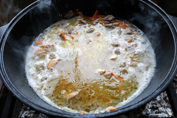 Preparation pilaf in cauldron on fire