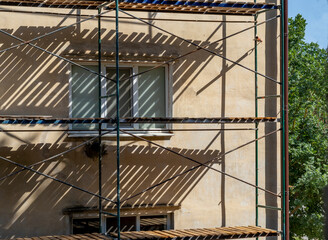Major repairs of an old five-story apartment building. Insulation of facade with mineral wool with subsequent finishing. Building is surrounded by scaffolding