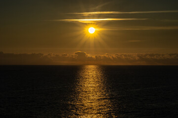 The sun sets between the clouds in the Cantabrian Sea on a summer day!