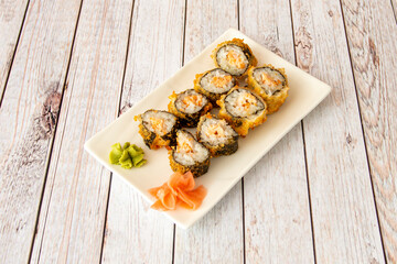Sushi tray maki salmon with nori seaweed in fried tempura with wasabi and ginseng