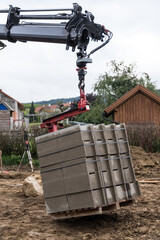 LKW-Kran entlädt Baustoffe bei Baustelle