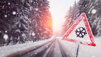 warning sign about the snowfall on the snowy road