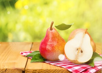 One and a half fresh ripe pear fruit with leaf on the desk