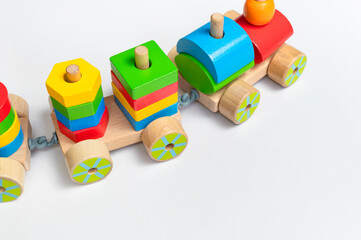 Wooden train with colored blocks on white background. Kids toys made of natural wood in rainbow colors. Eco friendly toy, game, plastic free. Toy for babies and toddlers. Flat lay