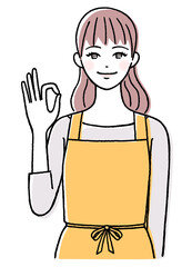 エプロンを着てOKサインを出す若い女性