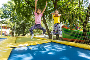 Little child enjoys jumping on trampoline - outside in backyard