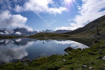 Obraz premium High altitude mountain landscape with the mountain reflected in a lake and a sunset