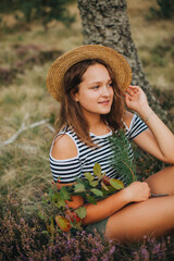 Young girl in the autumn forest. The girl in the hat. heather blooms in autumn