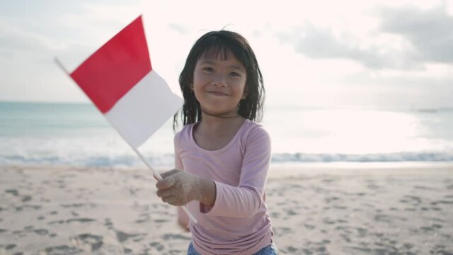 indonesian child with flag in the beach