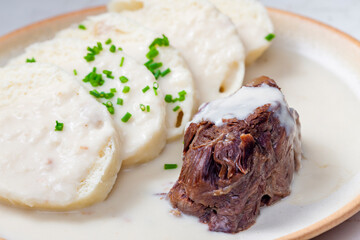 beef meat with white cream sauce and dumplings