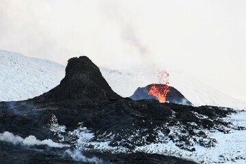 Two vents at the Fagradalsfjall eruption in Iceland. Black lava field in the foreground,...