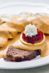 sirloin sauce with dumplings and cranberries on lemon with whipped cream