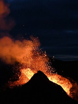 Eruption at Fagradalsfjall, Iceland. Red and orange incandescent lava is erupted from the volcanic vent. Taken at night, the lava is isolated on a black background.