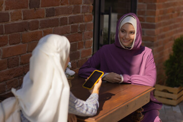 Islamic beautiful woman in a Muslim dress standing on a summer park street background forest autumn...
