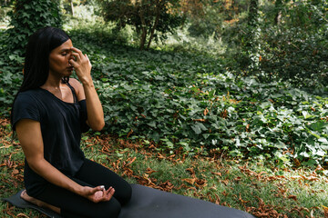 a girl doing yoga in nature dressed in black