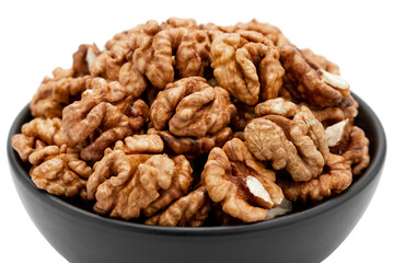 Close-up of shelled walnuts in a bowl isolated on white background, angled view. Template for designers.