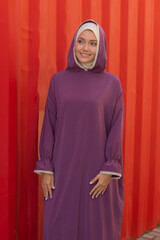 Islamic beautiful woman in a Muslim dress standing on a summer park street background forest autumn...