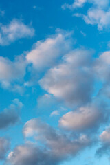 Blue sky with many small cumulus clouds illuminated by the sun as a natural background