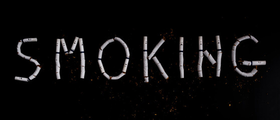 Text smoking made from broken cigarettes with faces painted on black background
