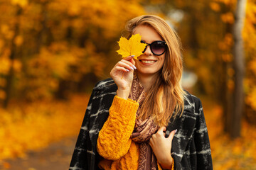 Happy beautiful young girl with a sweet smile in a yellow vintage knitted sweater and a fashionable...