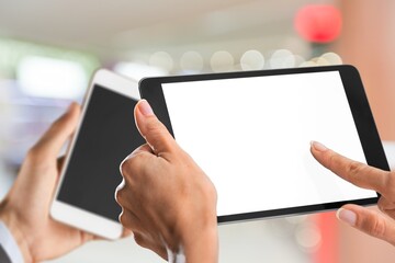 Two modern smartphones with blank screens in human hands