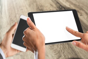 Two modern smartphones with blank screens in human hands
