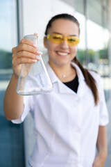 Scienсe, chemistry, biology and medicine concept - European smiling female scientist in protective...